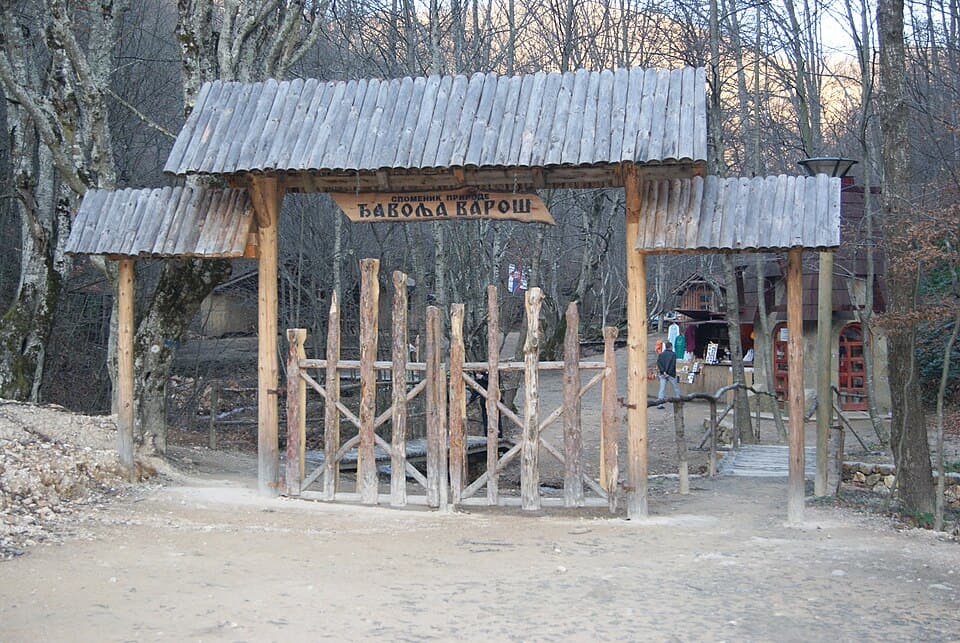 Mala drvena crkva Svete Petke okružena šumom na ulazu u lokalitet.