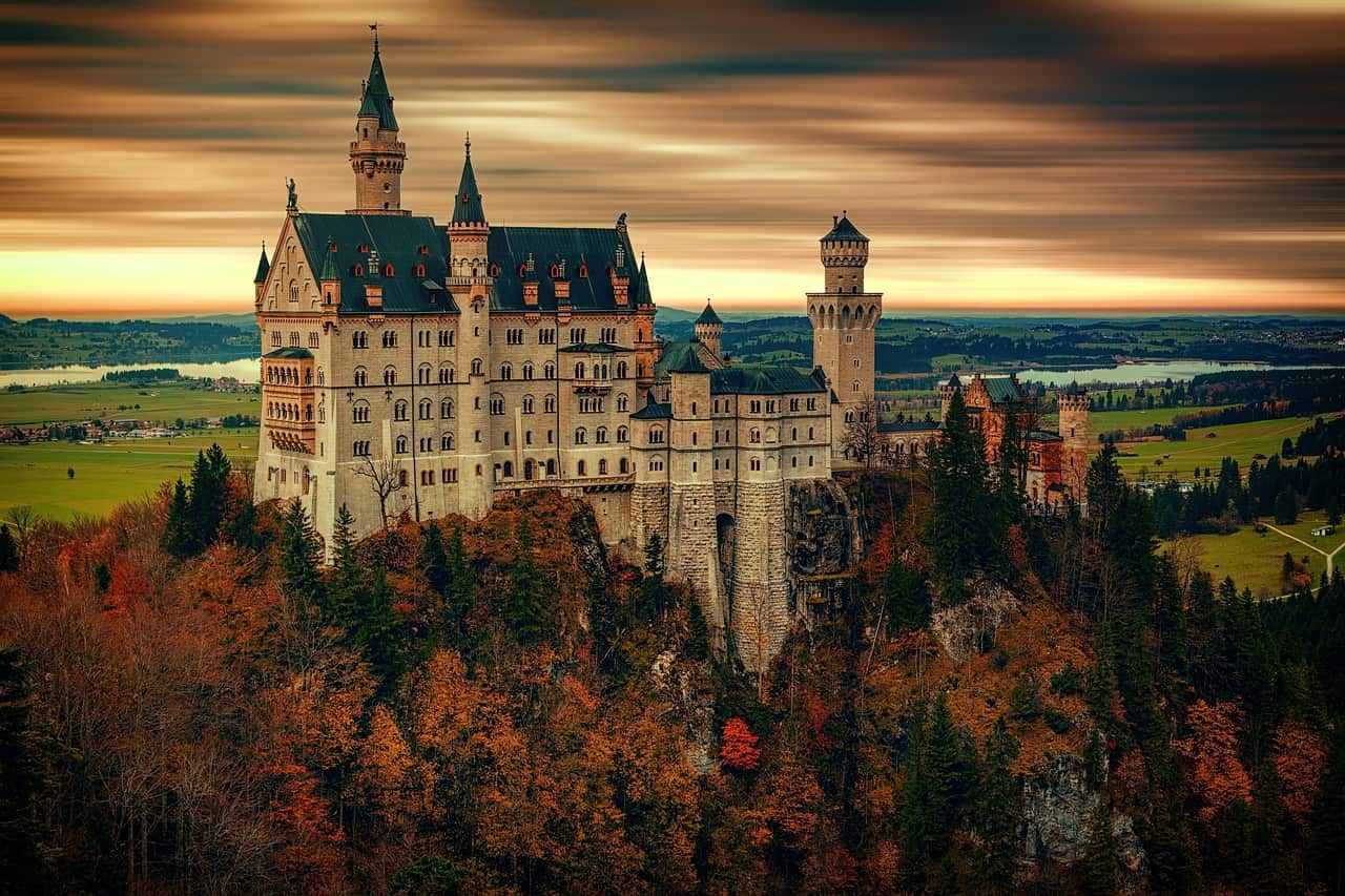 Dvorac Neuschwanstein sa bijelim tornjevima na vrhu šumovitog brda u Bavarskoj.