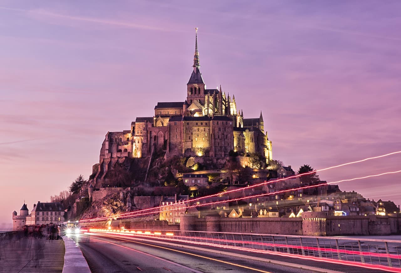 Pogled na Mont Saint-Michel usred mora, sa visokim tornjem opatije u centru.
