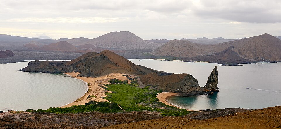 pinnacle rock na ostrvu bartolome sa ostrvom santiago u pozadini galapagos